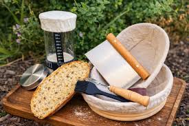 Sourdough baking setup with a scale, proofing basket, dough whisk, and rustic bread tools